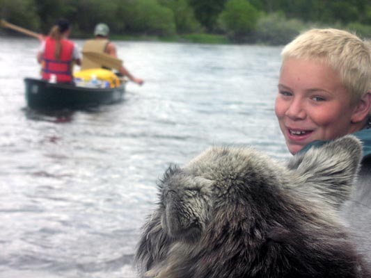 Boy smiling while canoeing.